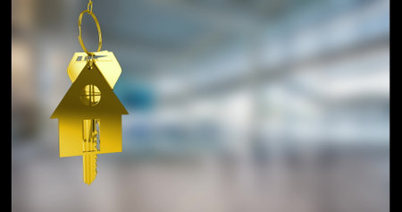 Image of golden house keys hanging against blurred background with copy space. Relocation and real estate conceptの写真素材