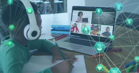 Image of globe of digital icons on african american boy doing homework looking at laptop at home. School and education technology conceptの写真素材