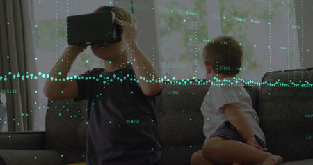Image of financial data processing over boy using vr headset. Global technology, computing and data processing concept digitally generated image.の写真素材