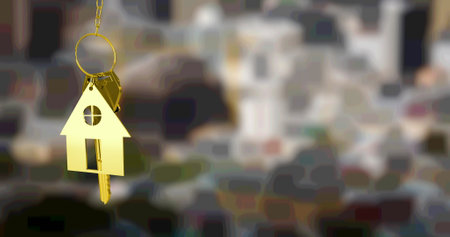 Image of gold house key fob and key, hanging in front of blurred city view. property business, home and finance concept digitally generated image.の写真素材
