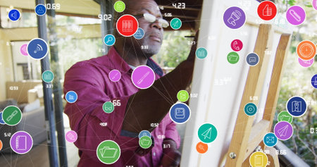 Image of social media icons over african american man painting. global connections, digital interface and communication concept digitally generated image.の写真素材