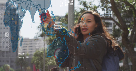 Image of data processing over biracial woman talking on smartphone. Global business and digital...