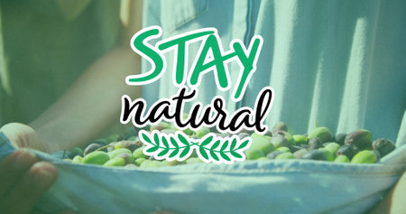 Image of stay natural text over caucasian man picking fruit. Global ecology, organic and digital interface concept digitally generated image.の写真素材