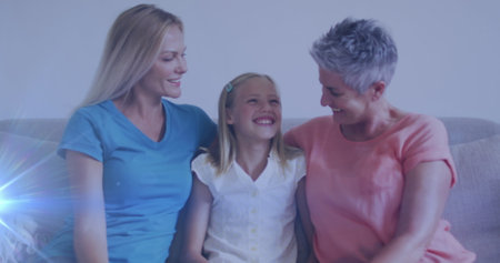 Image of glowing spots over happy caucasian grandmother, mother and daughter. mother&#39;s day and motherhood concept digitally generated image.の写真素材