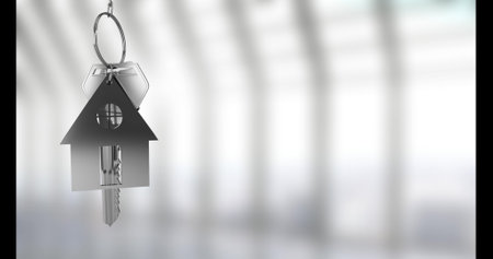 Image of silver house keys hanging against blurred background with copy space. Relocation and real...
