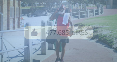 Image of media icon over senior african american man using smartphone at beach. healthy, active...