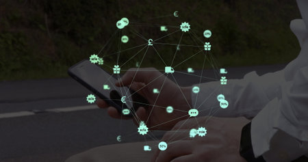 Globe of digital icons spinning against mid section of a man using smartphone on the street. Social media networking and technology conceptの写真素材