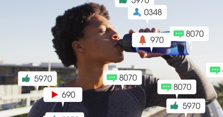 Image of notification bars, african american athlete standing and drinking water. Digital composite,...
