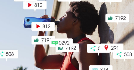 Image of icons, changing numbers in notification bars, african american athlete drinking water. Digital composite, multiple exposure, business, growth and social media reminder concept.の写真素材