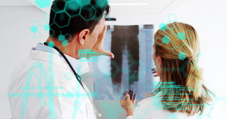 Image of scientific data processing over back of caucasian female and male doctors. medicine, health, science and technology concept digitally generated image.の写真素材