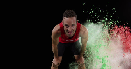 Image of colourful powders over male athlete resting. global sports and competition concept digitally generated image.の写真素材