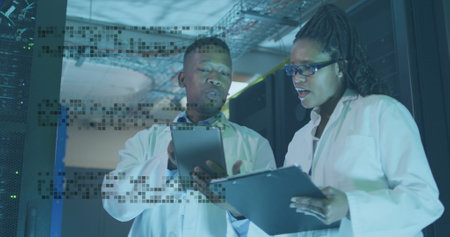 Image of shapes over african american workers in server room. Global business and digital interface concept, digitally generated image.の写真素材