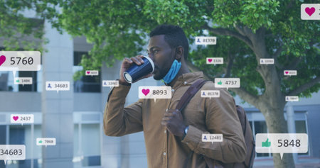 Image of social media icons over african american man drinking coffee on the street. Social media networking and covid-19 pandemic conceptの写真素材