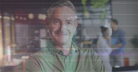 Image of statistical data processing, numbers over portrait of caucasian man smiling at office. Computer interface and business data technology conceptの写真素材