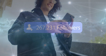Image of increasing followers on a speech bubble over over biracial man using a smartphone. Social media networking and business technology conceptの写真素材