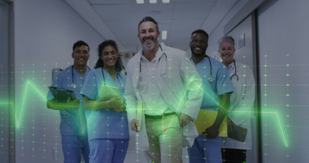 Image of heart rate monitor over team of diverse doctors and health workers smiling at hospital. Medical healthcare technology conceptの写真素材