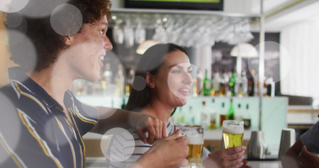 Image of white spot lights over diverse friends having drink in bar. Leisure, free time and...