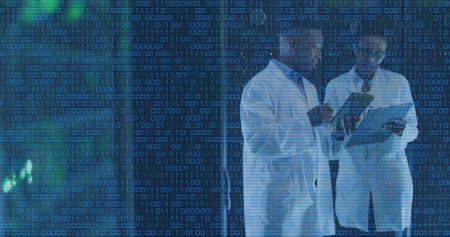 Image of binary coding over diverse male and female engineers discussing at server room. Global business and medical healthcare technology conceptの写真素材