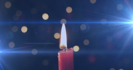 Image of lit candle with flickering spots of light. Remembrance celebration and tradition concept digitally generated image.の写真素材