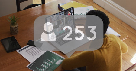Image of social media icon and numbers over african american businesswoman using laptop. Global...