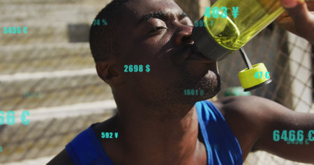 Image of changing numbers, currency symbols, tired african american athlete drinking water. Digital composite, multiple exposure, business, growth, sports and banking concept.の写真素材