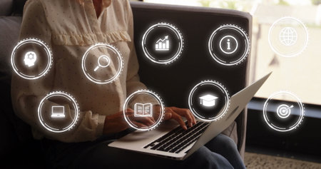 Image of multiple icon in circles over caucasian woman sitting on sofa and using laptop. Digital composite, multiple exposure, report, business, education, target and technology concept.の写真素材