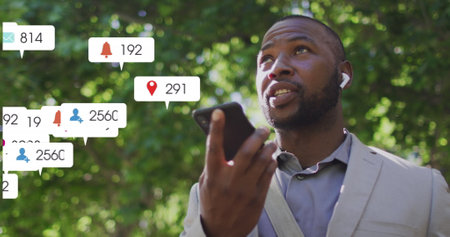 Image of notification bars over african american man talking on speaker of cellphone. Digital composite, multiple exposure, business, social media reminder and technology concept.の写真素材