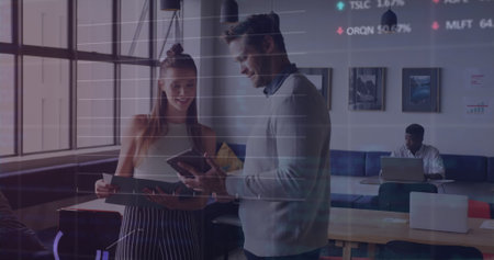 Image of stock market data processing against diverse man and woman discussing at office. Global economy and business data technology conceptの写真素材