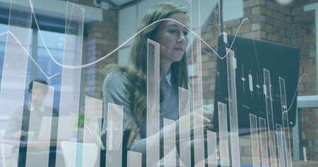 Image of financial data processing over caucasian businesswoman in office. Global computing, digital interface and data processing concept digitally generated image.の写真素材