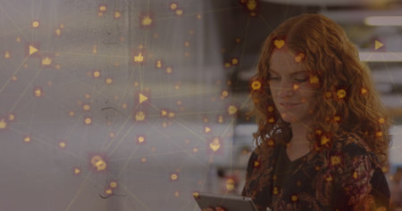 Image of network of connection with interface icons over Caucasian woman using digital tablet. Global networking and social media concept digital composite.の写真素材