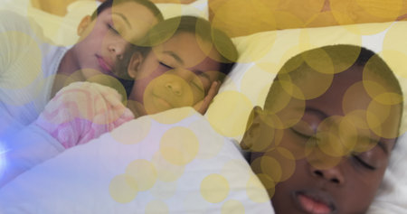 Image of dots moving over sleeping african american mother and kids. Family, spending quality time together concept digitally generated image.の写真素材