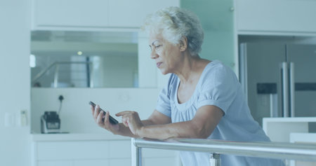 Image of financial data processing over senior african american woman using smartphone. Global...