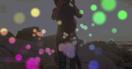 Image of light spots over african american couple at beach. Lifestyle and free time concept digitally generated image.の写真素材