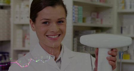 Image of financial data processing over caucasian female pharmacist. Global pharmaceuticals, business, finance, computing and data processing concept digitally generated image.の写真素材