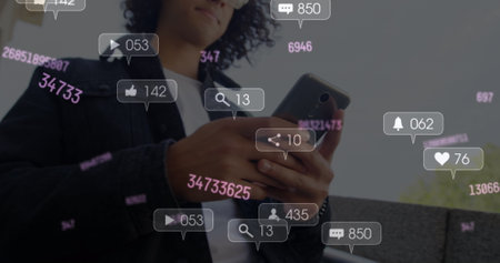 Image of changing numbers and social media icons over biracial man using smartphone. Social media networking and business technology conceptの写真素材