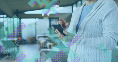 Image of x symbols over midsection of caucasian woman standing and scrolling on smartphone. Digital...
