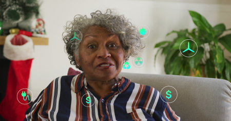 Image of icons over senior african american woman having image call. Global lifestyle, communication and digital interface concept digitally generated image.の写真素材