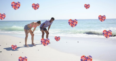 Image of hearts moving over diverse couple in love on beach in summer. Love, romance, valentine&#39;s day and vacation concept digitally generated image.の写真素材
