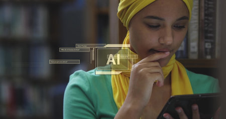 Image of ai text and data over biracial female student in hijab with tablet. Global artificial intelligence, connections, computing and data processing concept digitally generated image.の写真素材
