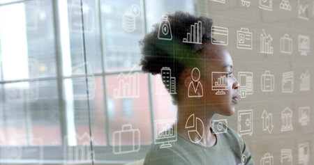 Image of business icons over smiling african american casual businesswoman at office. Work,...