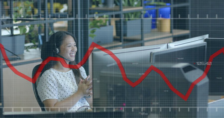 Image of financial data processing over asian businesswoman in office. Global finance, business, connections, computing and data processing concept digitally generated image.の写真素材