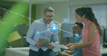 Image of network of connections with icons over diverse colleagues using tablet in office....