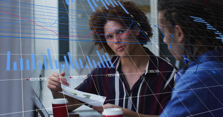 Image of blue charts processing data over diverse male colleagues talking at casual office. Business, connection, teamwork, digital interface and communication, digitally generated image.の写真素材