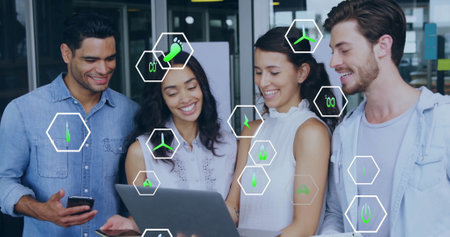 Image of ecology icons over diverse colleagues using laptop in office. Business, technology and digital interface concept digitally generated image.の写真素材
