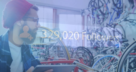 Man holding tablet in bicycle shop with 329,020 Followers image over. Technology, retail, business,...