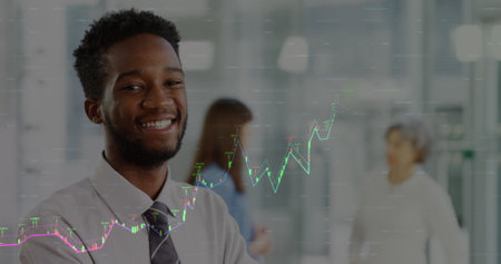 Image of financial data processing over african american businessman smiling. Global business, finances and digital interface concept, digitally generated image.の写真素材