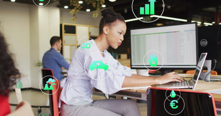 Image of icons over african american businesswoman using laptop at office. Global business,...