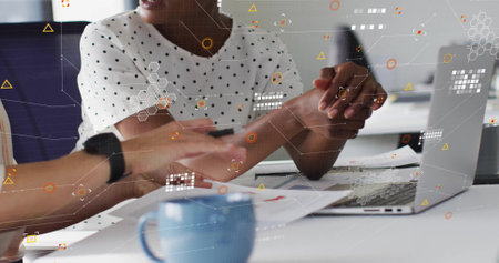 Image of processing data over happy diverse female colleagues using laptop at casual office....