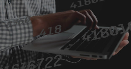 Image of data processing over hands using laptop. Global business and digital interface concept digitally generated image.の写真素材