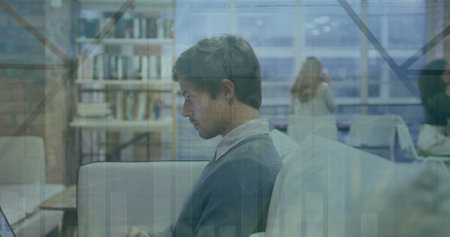 Image of multiple graphs and leaves over focused caucasian businessman working over laptop. Digital...